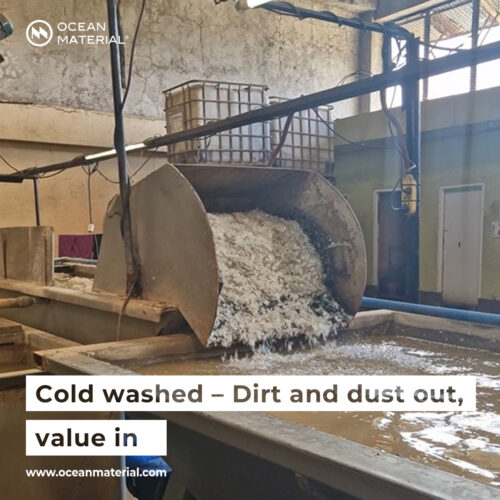 Cold washing process at a plastic recycling facility, where shredded plastic is cleaned in a rotating drum. Text overlay reads: “Cold washed – Dirt and dust out, value in”.